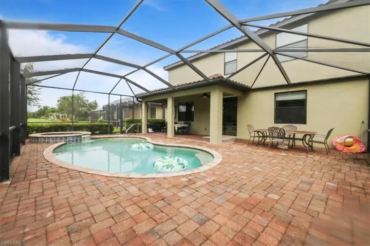 View of swimming pool featuring a patio area, a sunroom, a pool with connected hot tub, ceiling fan, and glass enclosure