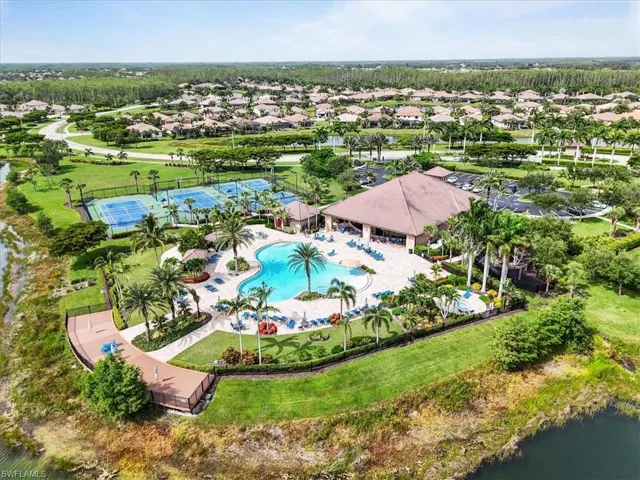 Aerial view of residential area featuring a pool and a large body of water