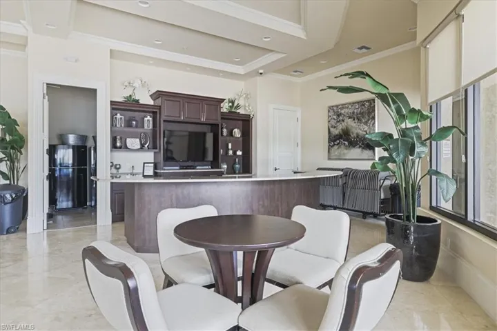 Dining area with crown molding, a raised ceiling, and recessed lighting