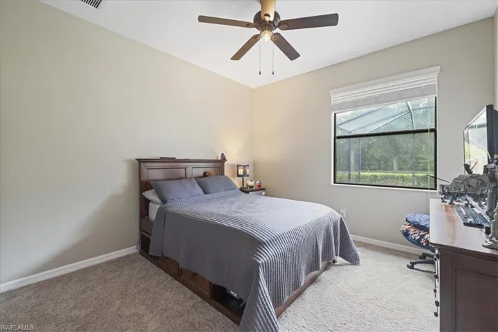 Carpeted bedroom with baseboards and a ceiling fan
