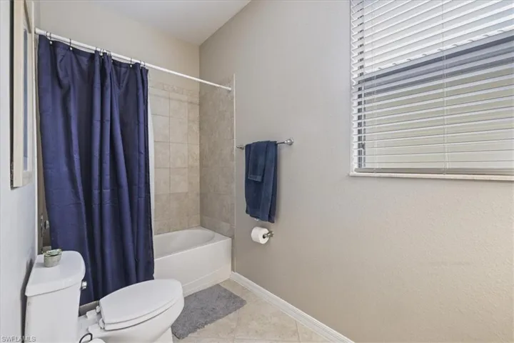 Bathroom with tile patterned floors and shower / bath combination with curtain