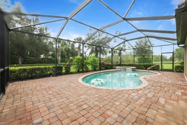 View of pool featuring a sunroom, a patio, a pool with connected hot tub, and a lanai