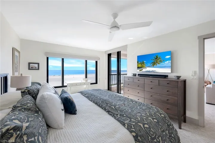 Bedroom with ceiling fan and light carpet