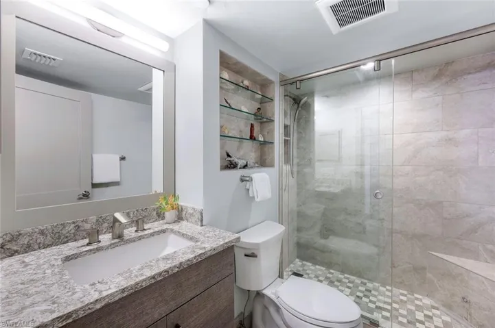Bathroom featuring vanity, toilet, and walk in shower