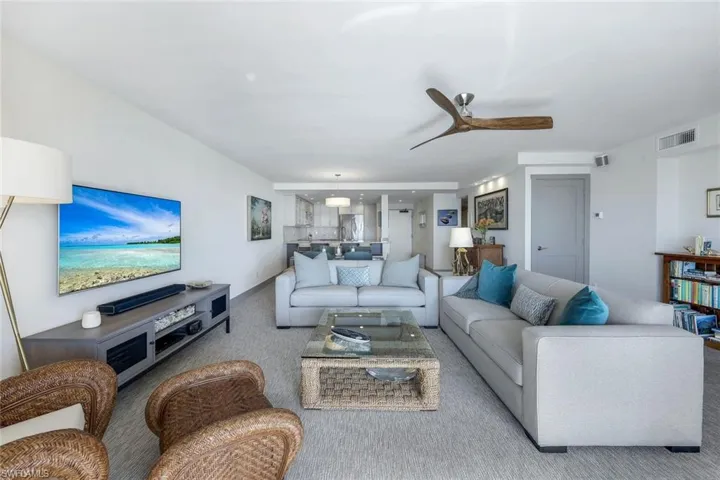 Carpeted living room with ceiling fan