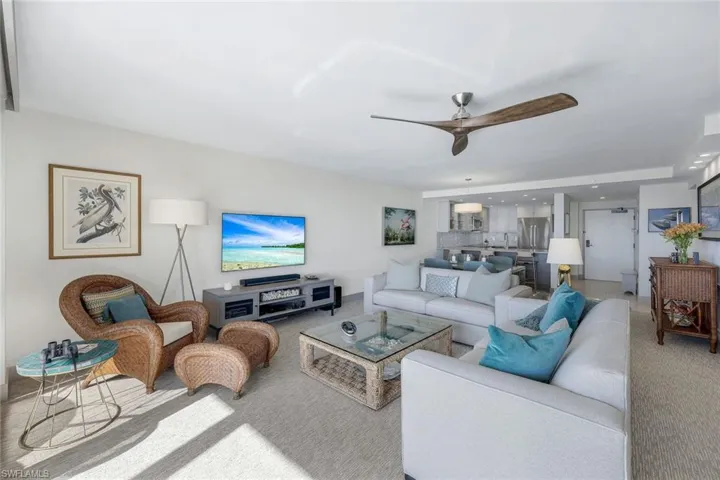 Carpeted living room featuring ceiling fan