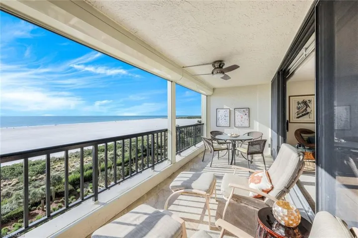 Balcony with ceiling fan, a water view, and a beach view