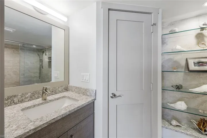 Bathroom featuring a tile shower and vanity