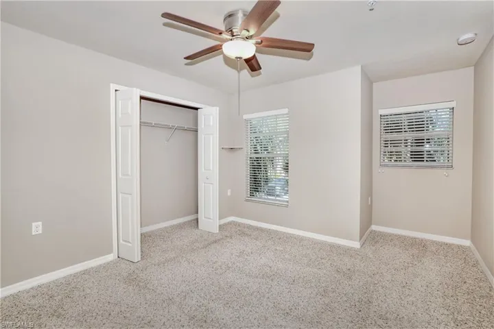 Unfurnished bedroom featuring carpet floors, baseboards, a closet, and a ceiling fan