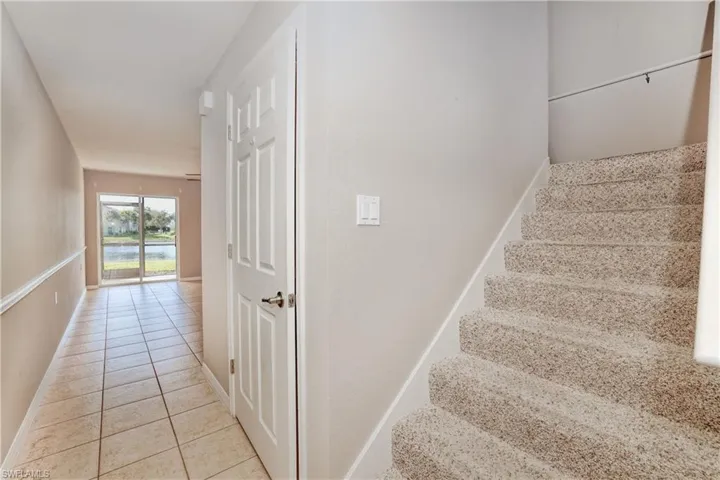 Stairs with tile patterned flooring and baseboards