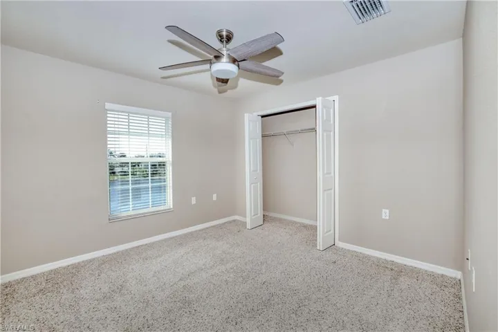Unfurnished bedroom with carpet floors, baseboards, a closet, and ceiling fan