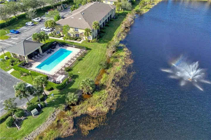Drone / aerial view of a pool area and a nearby body of water