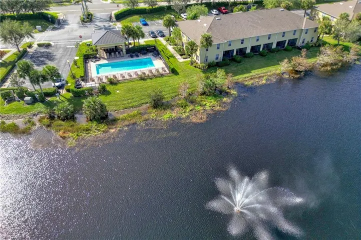 Drone / aerial view of a pool area and a nearby body of water