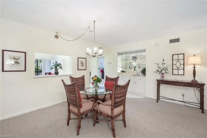Carpeted dining area featuring a notable chandelier
