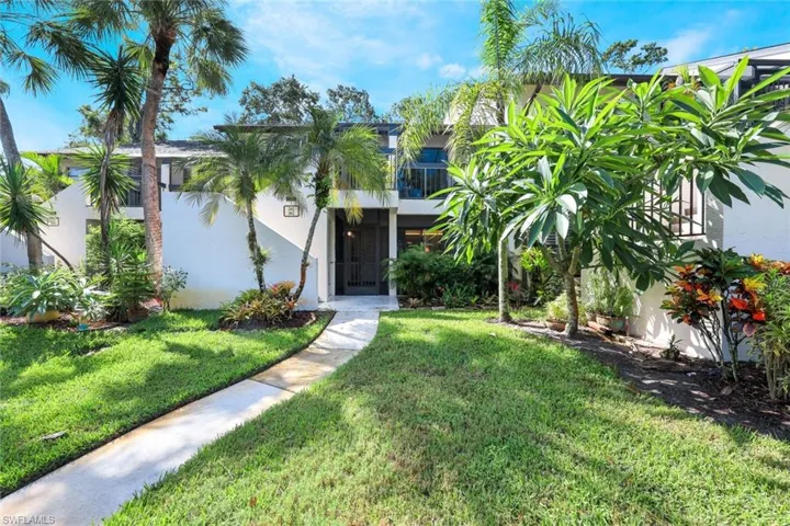 View of front of condo featuring a front yard and lanai
