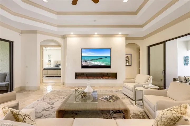 Stunning open living room with fireplace, built in TV and custom sound system. Opens to both screened in courtyard and back lanais