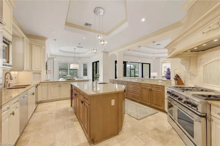 A Chef's inspired kitchen with gas range, double oven and island with prep sink.