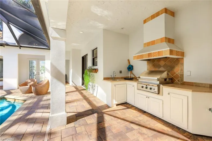 outdoor kitchen with exhaust hood and sink.