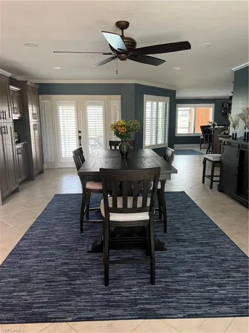 Prior to Hurricane  Helene Tiled dining space featuring ornamental molding and ceiling fan