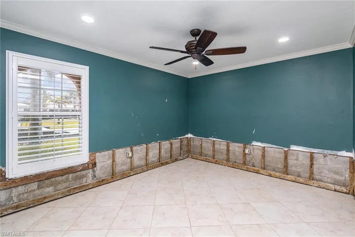Guest room with crown molding and ceiling fan