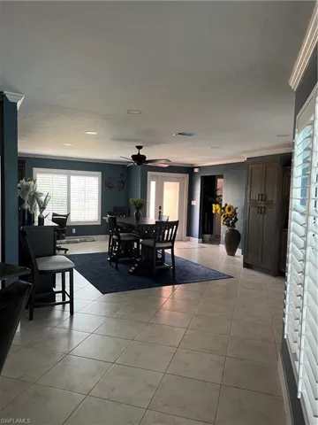 Prior to Hurricane  Helene Tiled dining space with crown molding and ceiling fan