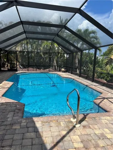 Prior to Hurricane  Helene  View of pool featuring a patio area and glass enclosure