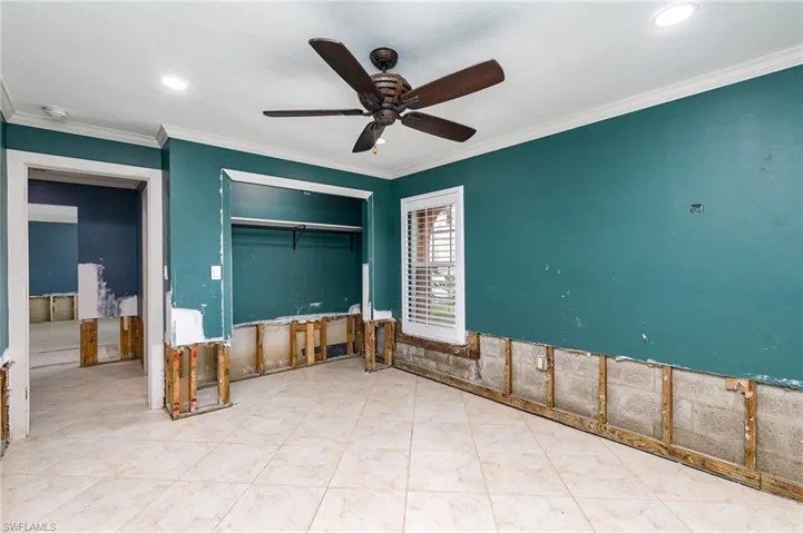 Guest bedroom room with ceiling fan and ornamental molding