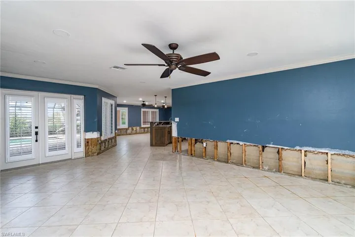 Spare room with french doors, crown molding, light tile patterned floors, and ceiling fan