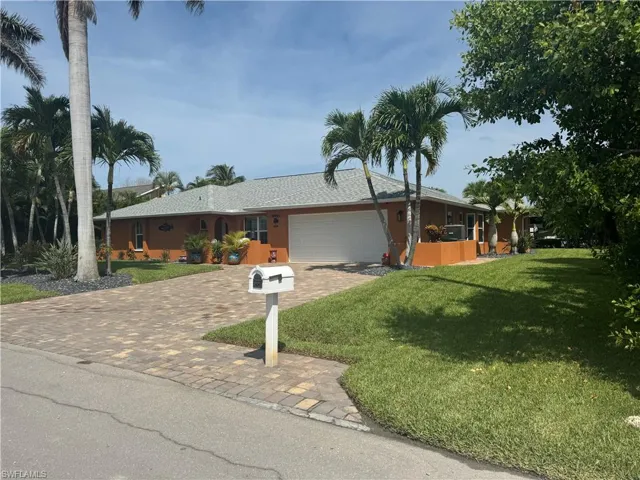 Prior to Hurricane  Helene  Ranch-style house with a front lawn and a garage