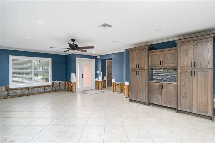Kitchen featuring ornamental molding, light tile patterned floors, and ceiling fan
