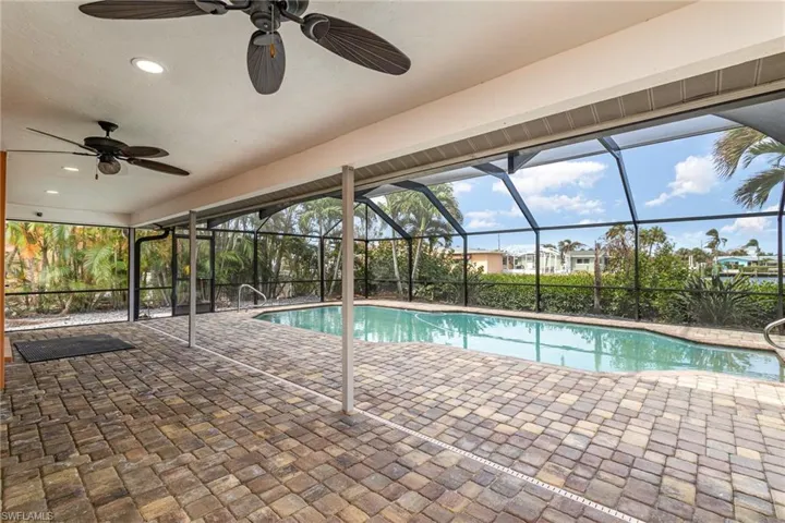 View of pool featuring a patio, ceiling fan, and a lanai