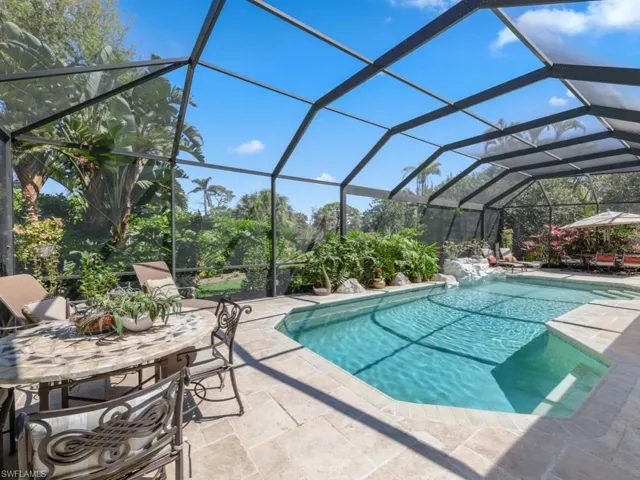 Outdoor pool with a patio area and glass enclosure
