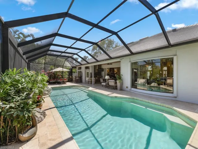 Outdoor pool with glass enclosure, a patio, and a ceiling fan