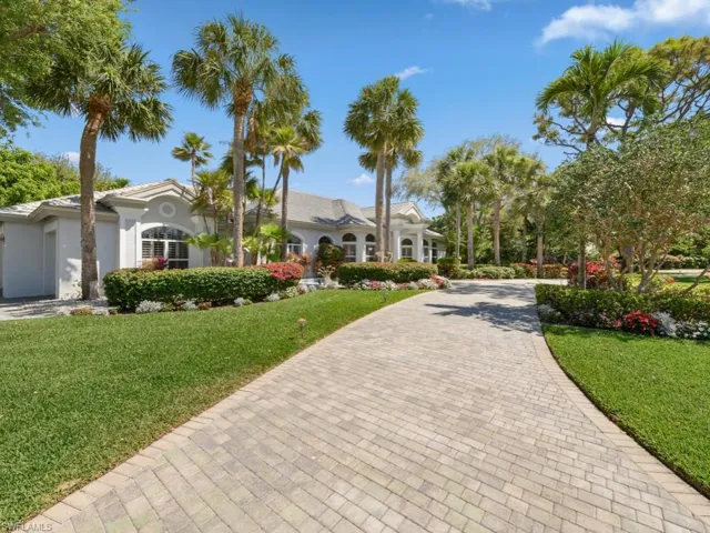 Mediterranean / spanish-style home with stucco siding, decorative driveway, and a front yard