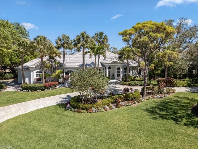View of front facade with a front yard, an attached garage, and driveway