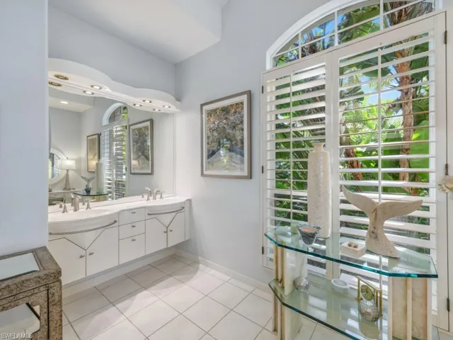 Bathroom with tile patterned flooring, double vanity, baseboards, and a sink