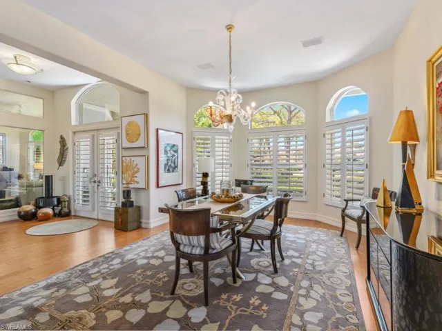 Dining space with visible vents, baseboards, french doors, an inviting chandelier, and wood finished floors