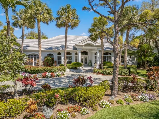 Back of house with a tile roof, french doors, driveway, and stucco siding
