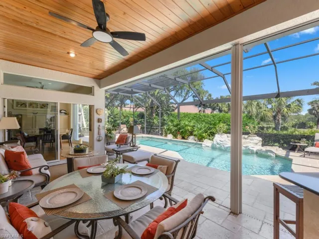 Outdoor pool featuring glass enclosure, a patio area, and a ceiling fan