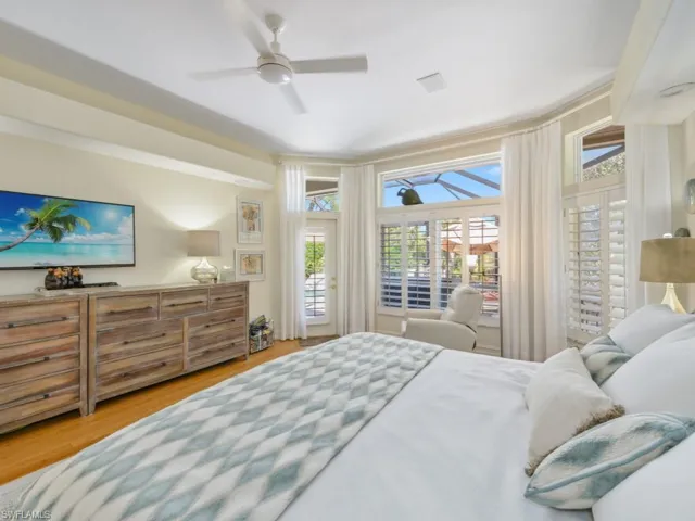 Bedroom featuring access to exterior, wood finished floors, and ceiling fan