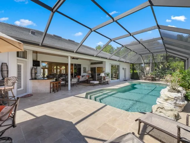 Pool with glass enclosure, a patio, an outdoor living space, ceiling fan, and outdoor dry bar