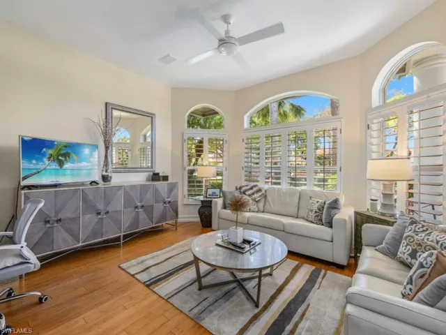 Living area with baseboards, wood finished floors, visible vents, and ceiling fan