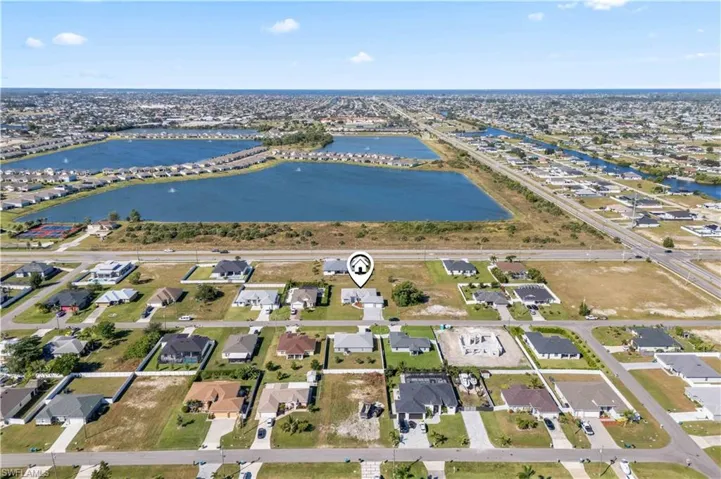 Aerial view of property and surrounding area with a nearby body of water and nearby suburban area