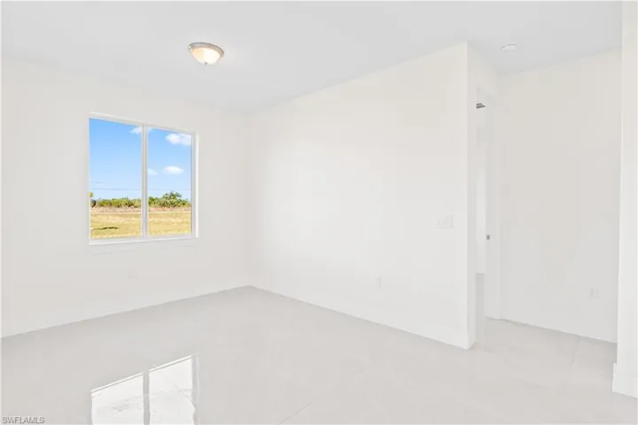 Empty room with baseboards and tile patterned floors
