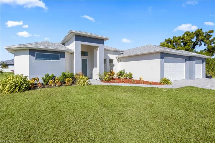 Prairie-style home with stucco siding, a front lawn, and an attached garage