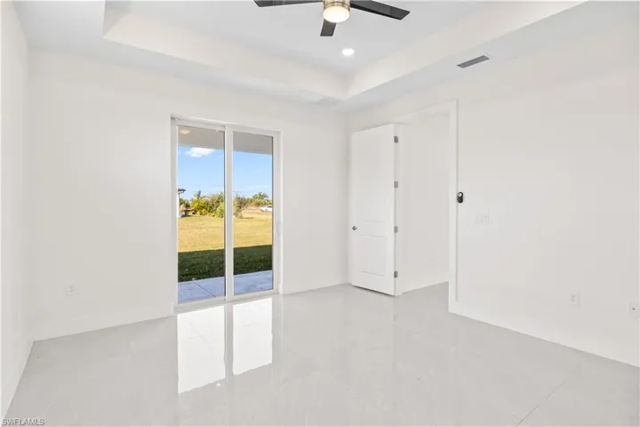 Unfurnished room with a raised ceiling, light tile patterned floors, and recessed lighting
