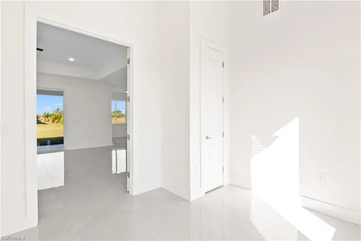 Hallway featuring baseboards and light tile patterned floors