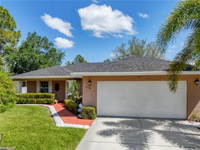 Single story home with stucco siding, a garage, concrete driveway, a front yard, and roof with shingles
