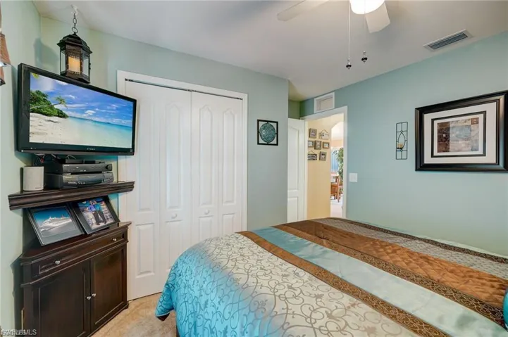 Bedroom featuring a closet, a ceiling fan, and light carpet