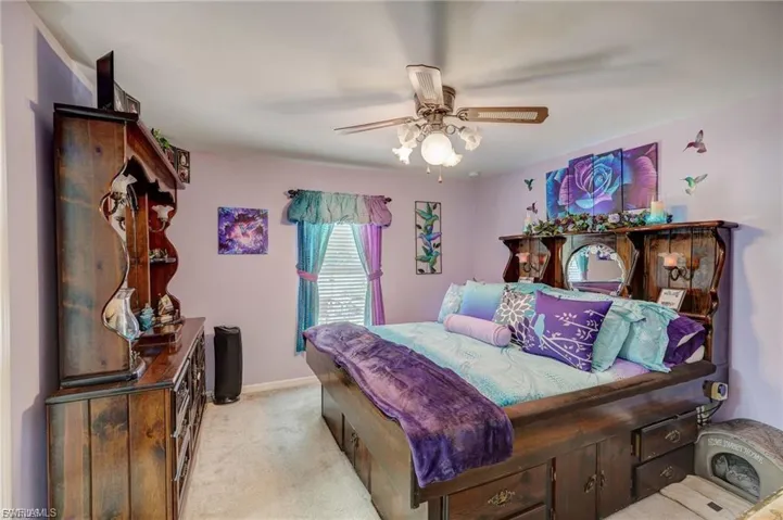 Bedroom with light carpet and a ceiling fan